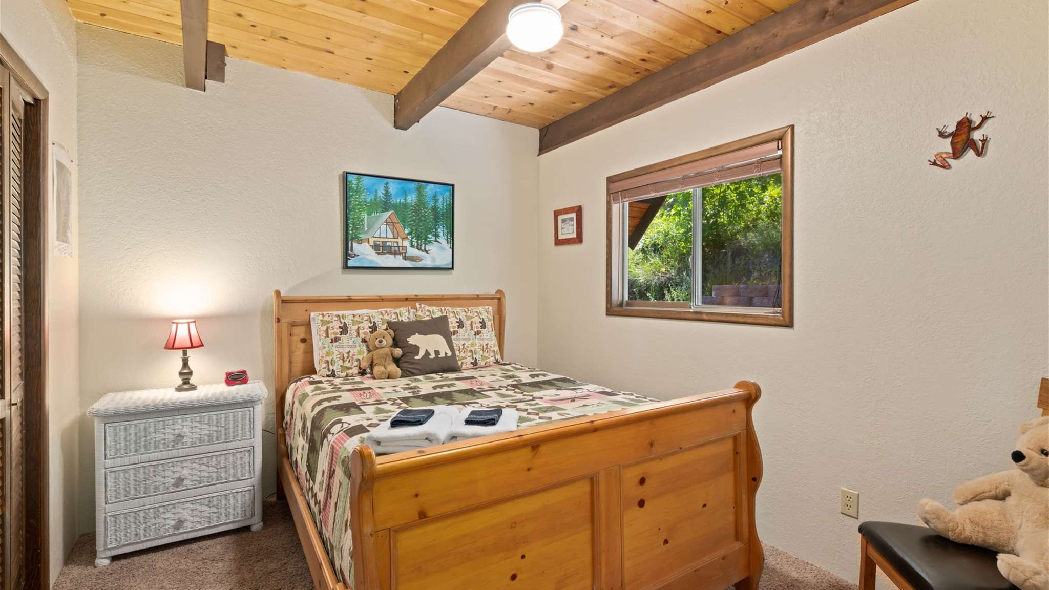 Main floor bedroom with queen bed and cabin charm.