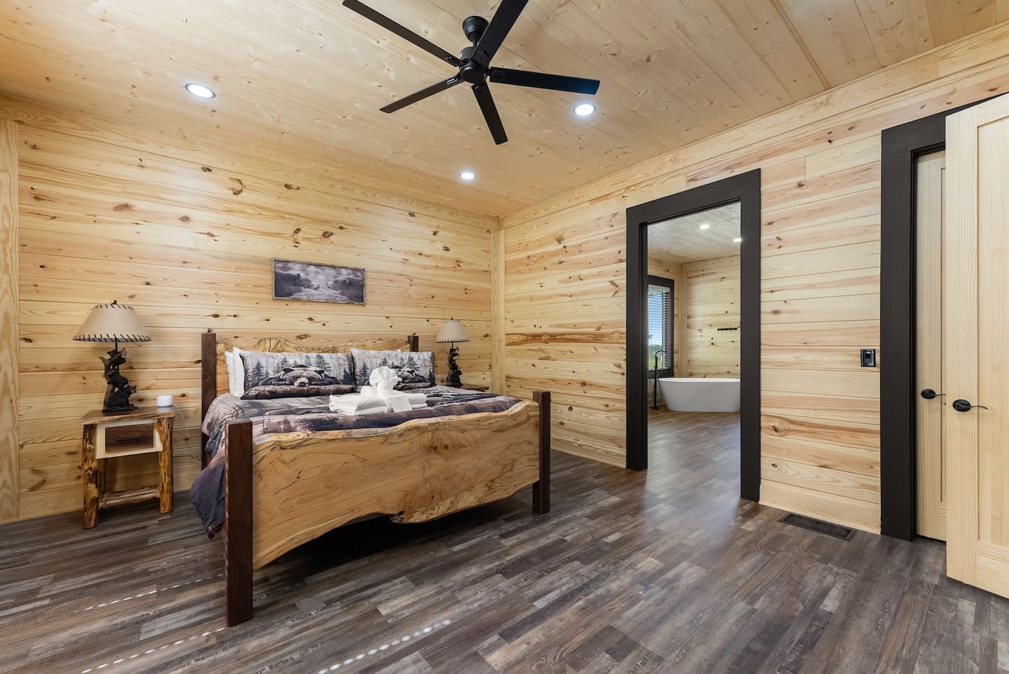 Drift into deep rest in this rustic king bedroom featuring custom log furnishings and direct access to a luxurious private bath.