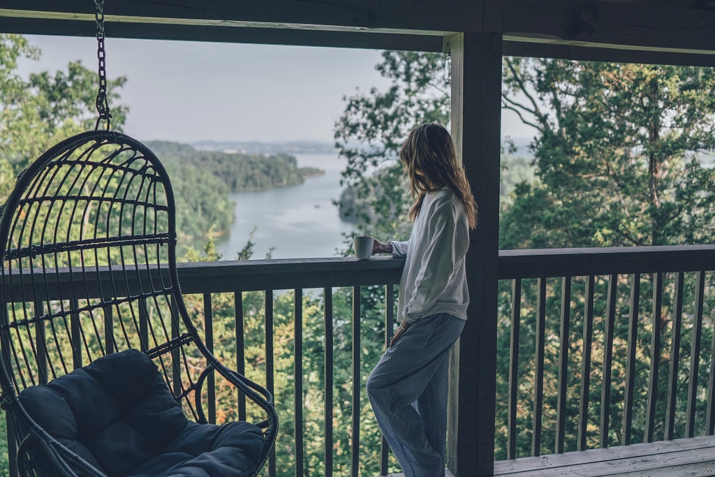 Sip morning coffee on the deck with sweeping lake and mountain views—pure serenity at Tippy Canoe Cabin