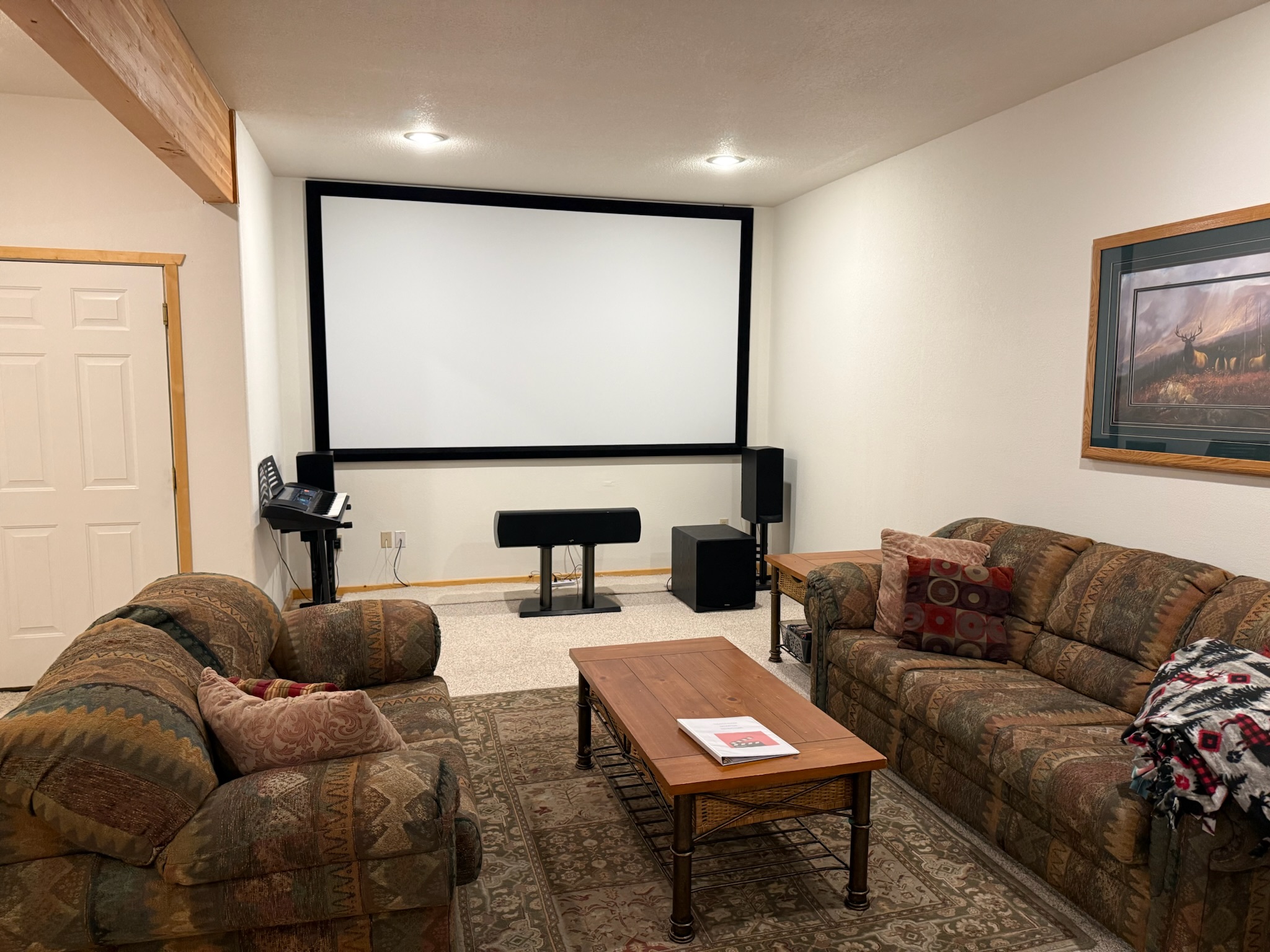 Entertainment center downstairs with large projector screen and sitting area
