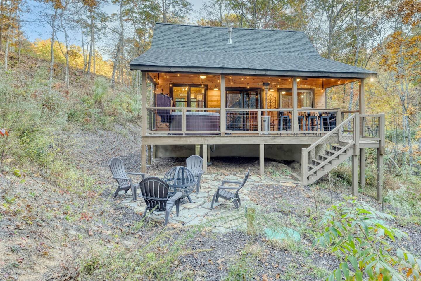 Behold the rustic charm of our cabin's front exterior, where the inviting glow of the fire pit sets the scene for evenings filled with laughter and memories under the starry sky.