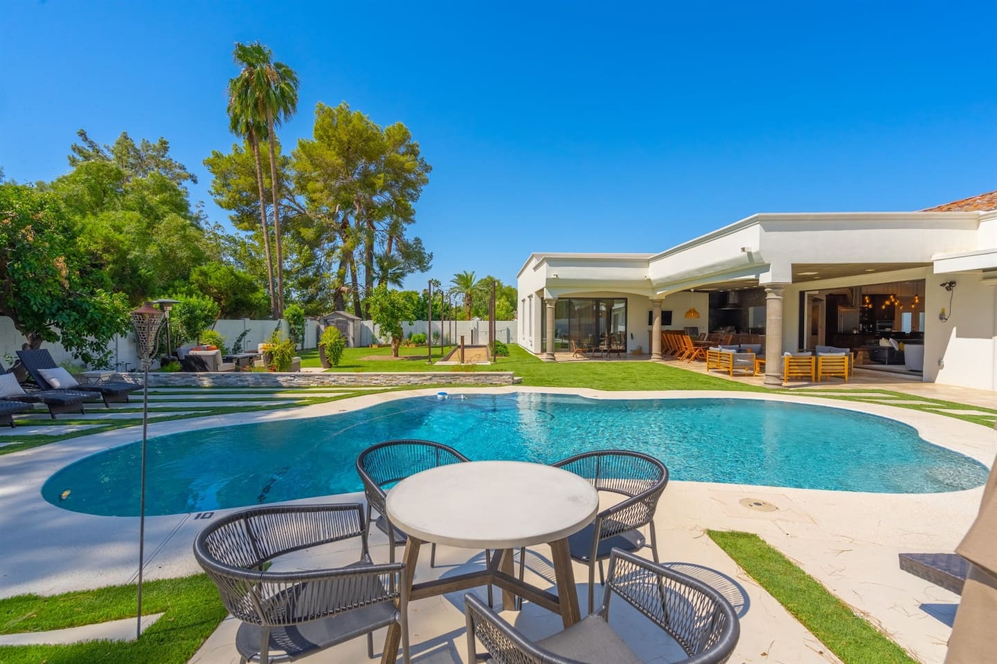 Enjoy a sunny day by the pool, surrounded by vibrant plants and inviting outdoor furniture.