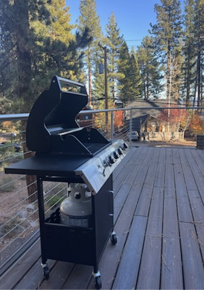 Outdoor gas BBQ grill on private deck, ideal for grilling and outdoor meals in a forest setting