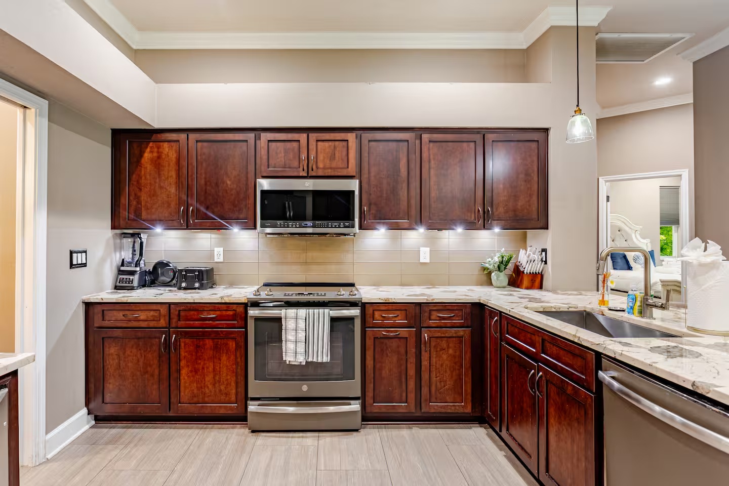 A fully equipped kitchen featuring rich wood cabinetry, granite countertops, stainless steel appliances, modern fixtures, and everything you need to prepare delicious meals during your stay.