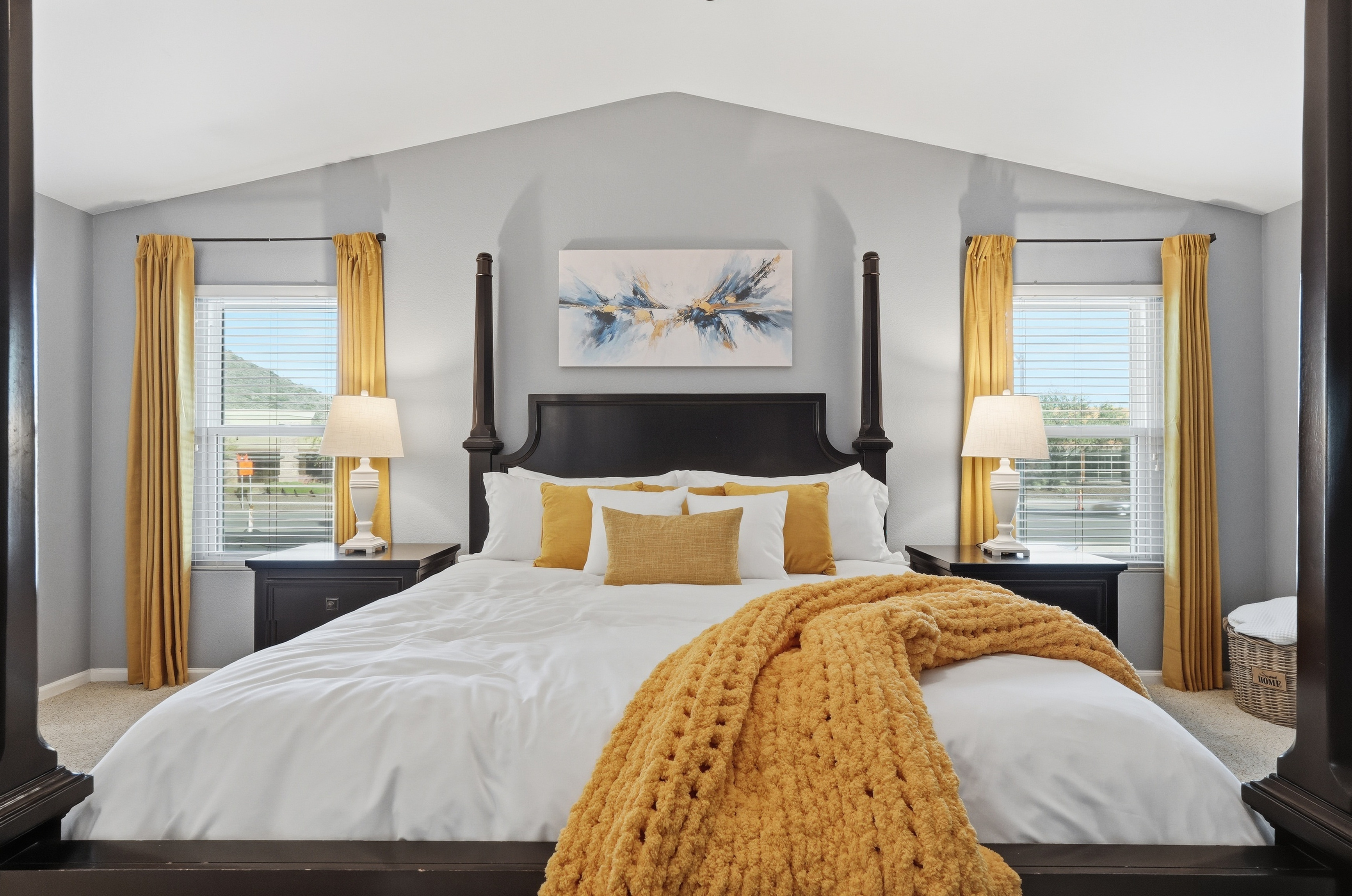 Primary bedroom with king bed, vaulted ceiling, bedside lighting, and mountain views for a restful stay.