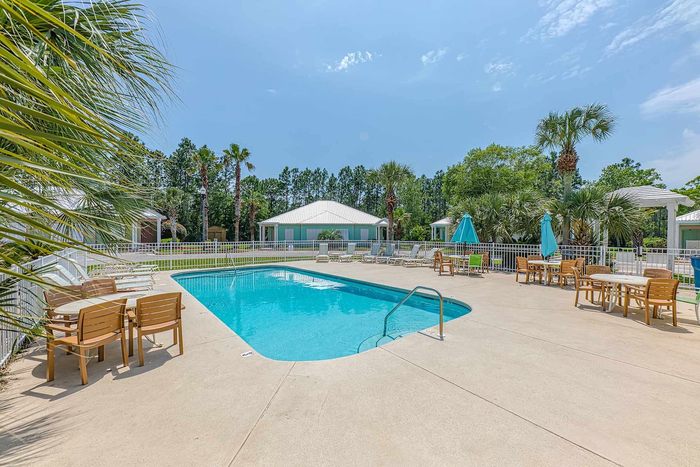 Poolside Paradise: Refreshing pool surrounded by palm trees and inviting lounge furniture awaits!