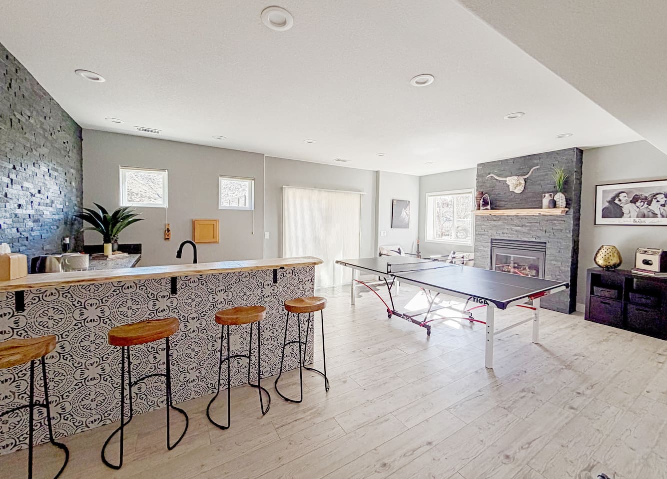 Tons of natural light and sliding doors fill the open space with natural light, creating a welcoming area for relaxing and entertaining in our basement game room!