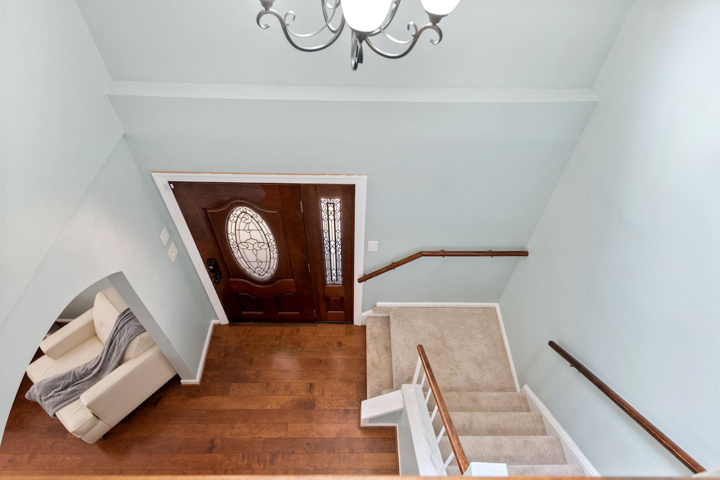 Bright and open foyer with elegant chandelier and stairway landing — a warm welcome that feels like home. 