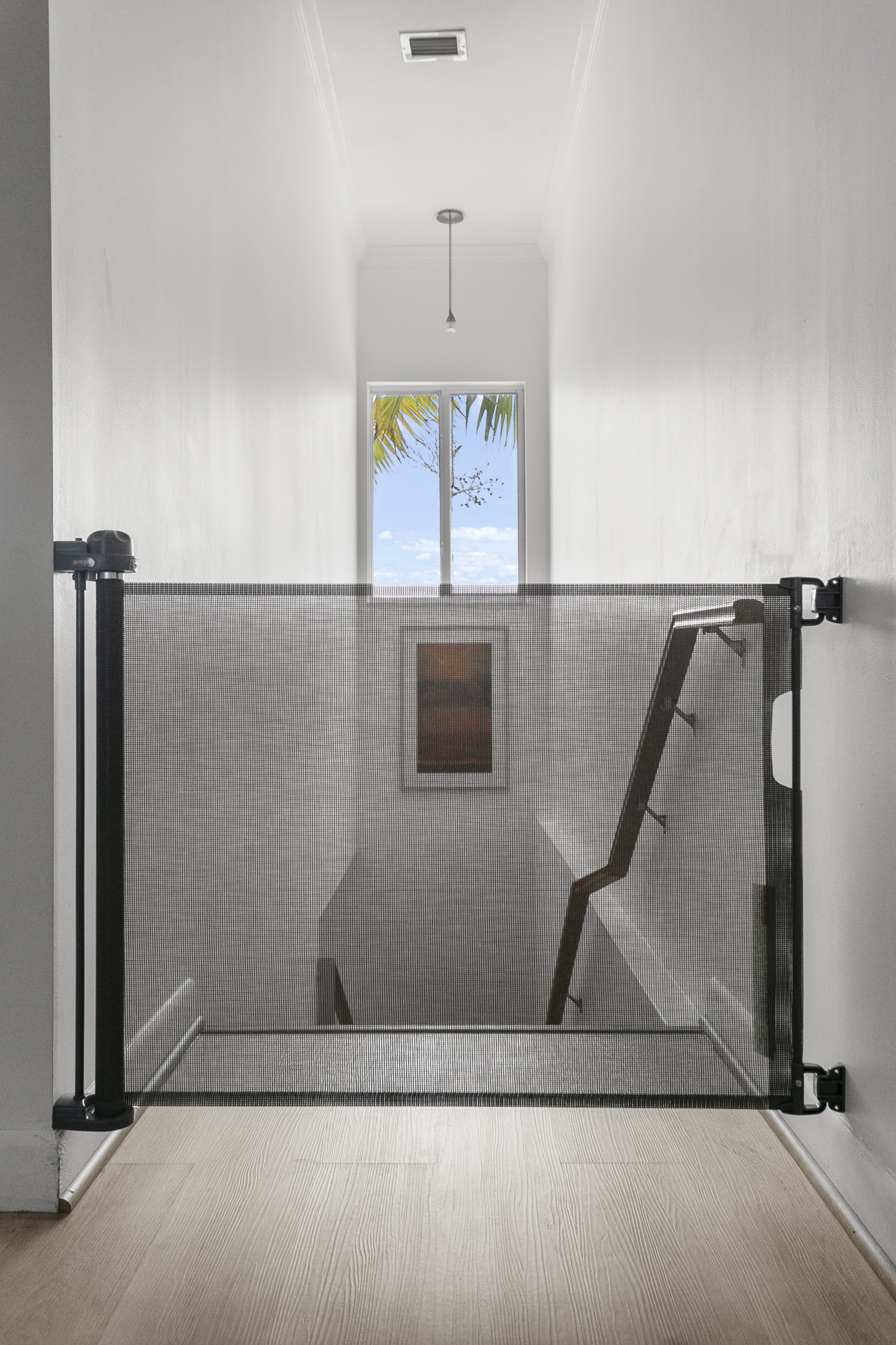 Retracting safety gate at top of stair landing
