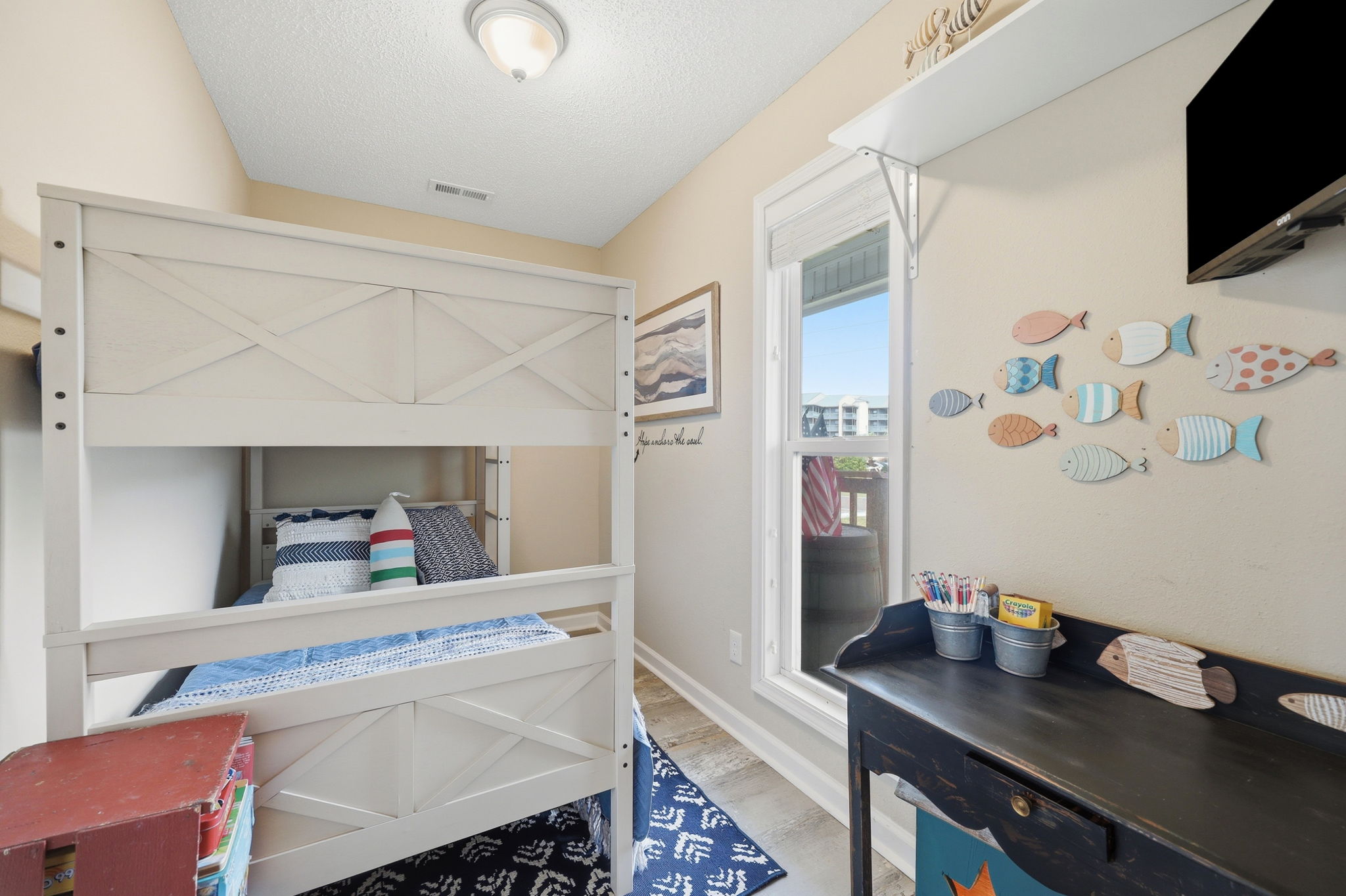 A kids room featuring a twin bunk bed, games, and more. The perfect hideaway for little beach explorers!