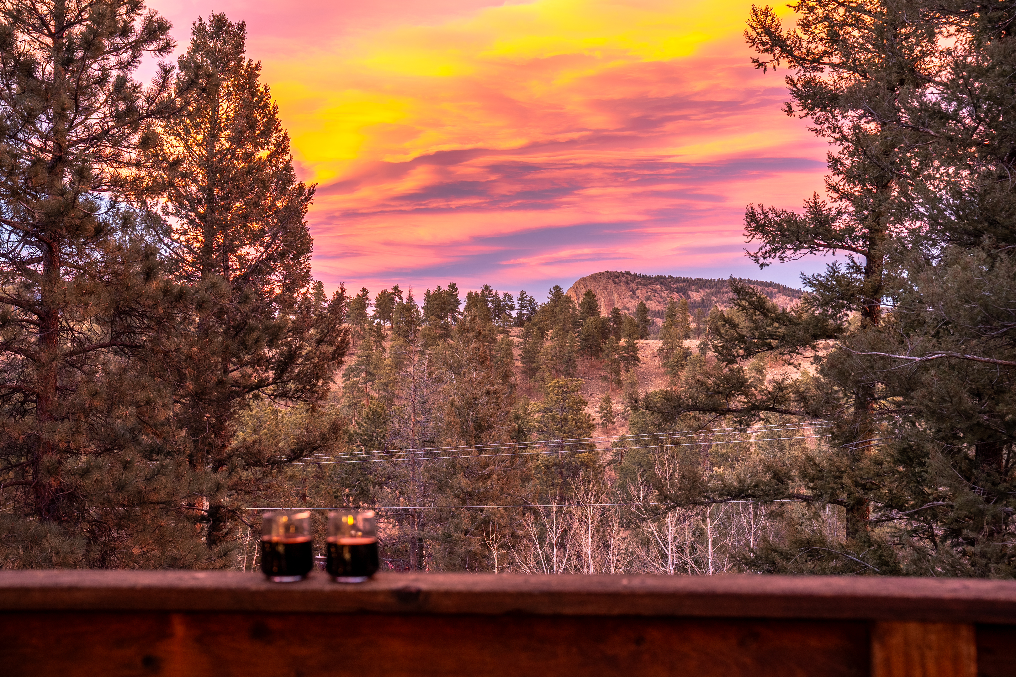 🌅🥂 Sunset perfection—watch the sky light up in color over the pines and mountain ridges, drink in hand, and zero rush to be anywhere else 🌲✨