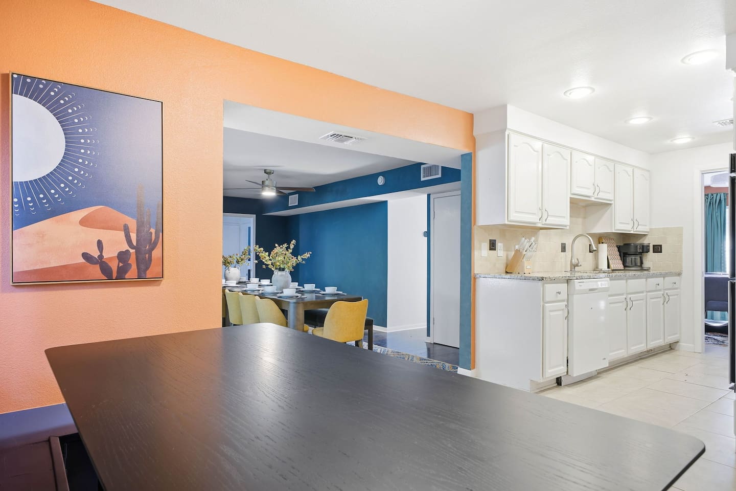 Dining nook table with the full kitchen to the right and the main dining area in the background