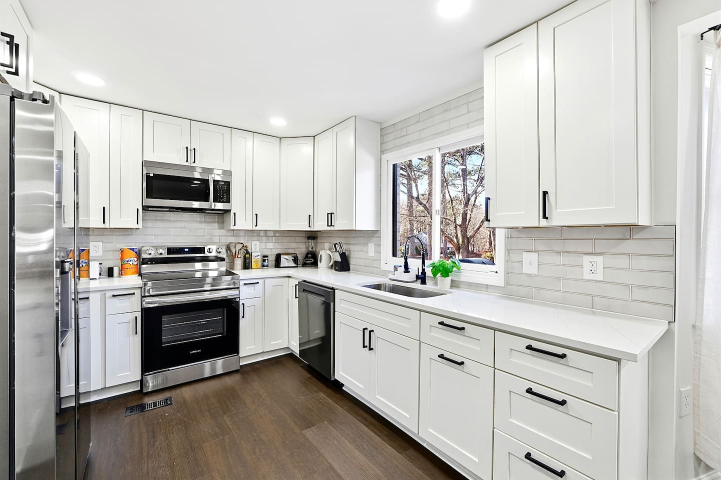 Bright white kitchen with a sleek, extended layout and ample counter space. The long layout offers plenty of countertop space, perfect for cooking, prepping, and everyday meals. Fully stocked with everything you need for a comfortable stay!
