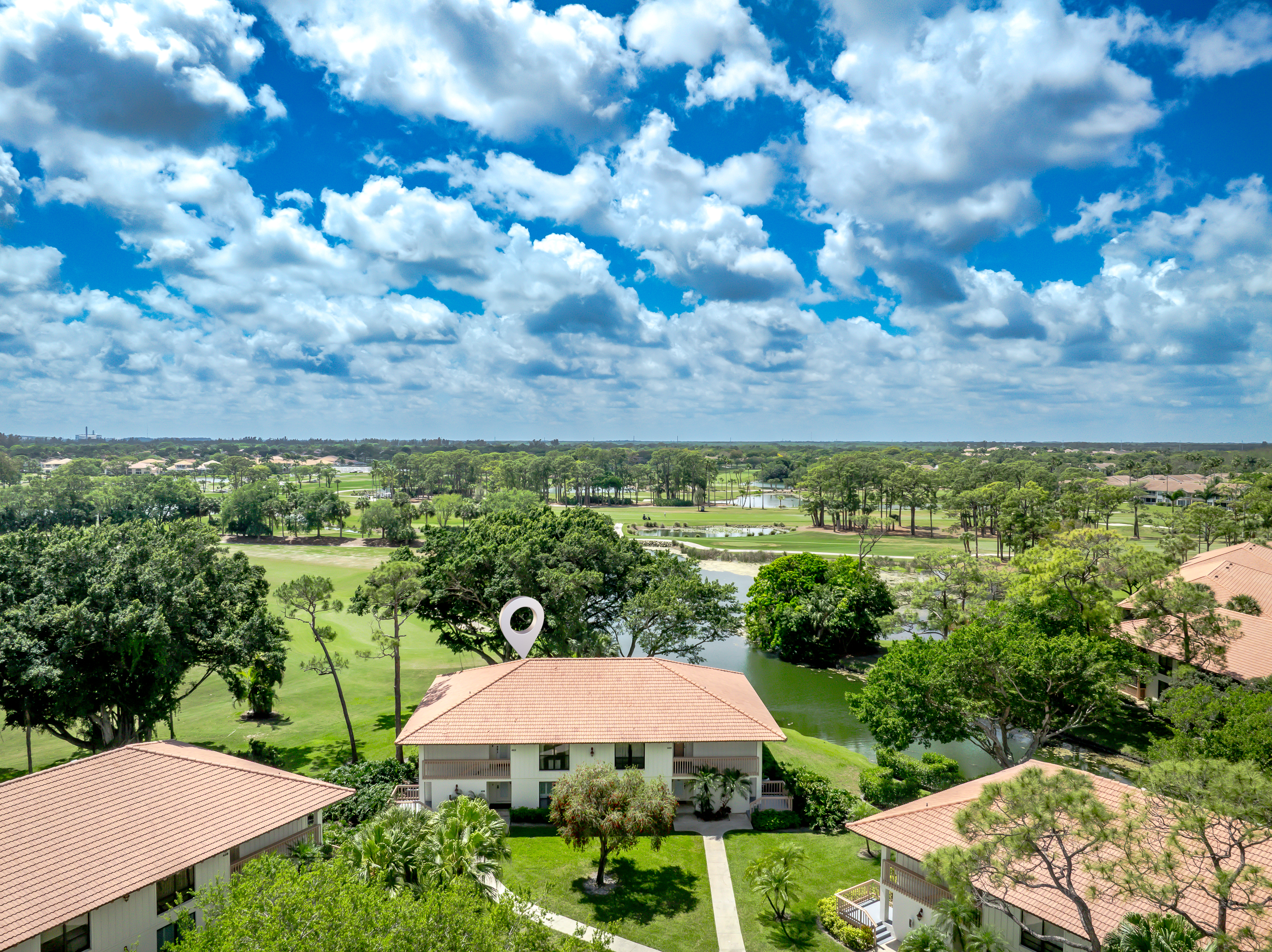 Aerial view showcasing lush golf course, water features, and serene surroundings