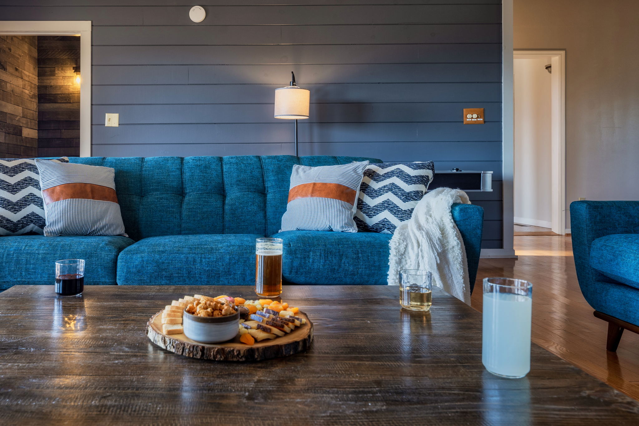 Modern elegance meets classic mountain cabin charm in the inviting living room, where soaring windows fill the space with natural light and frame breathtaking Smoky Mountain views right outside.