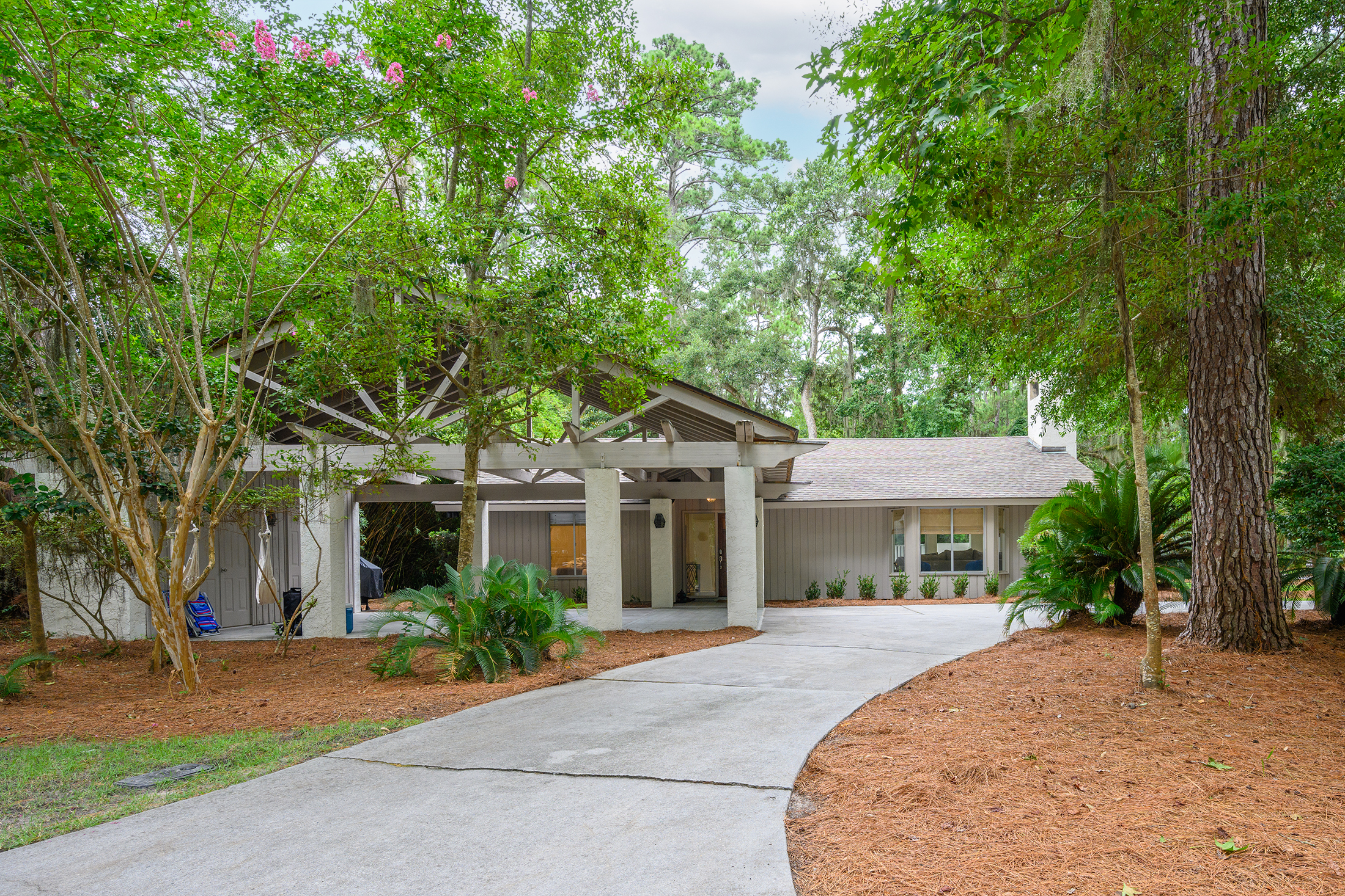 Circular drive and carport provide enough parking for up to 4 cars