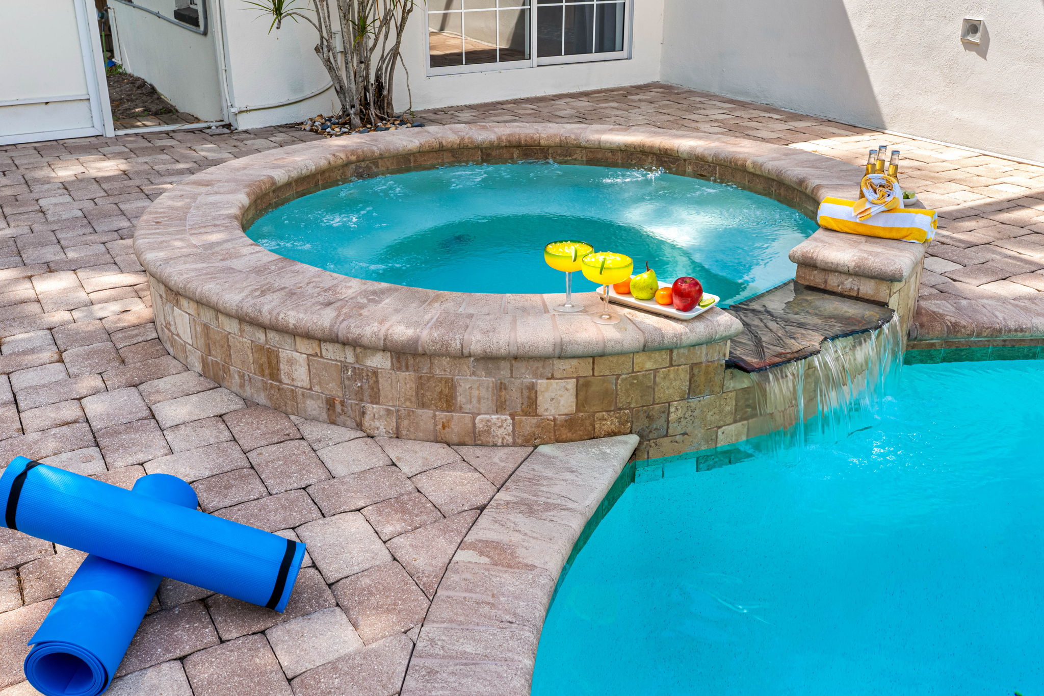 Crystal-clear pool with an attached bubbling spa creates the ultimate relaxation retreat.