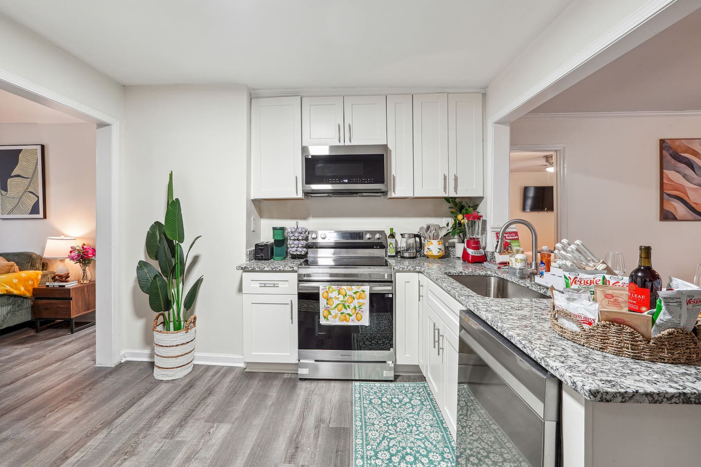 A fully equipped kitchen with a refrigerator, microwave, stove, oven,fridge, dishwasher, coffee maker, kettle, toaster, and blender. Includes plates, bowls, utensils, pots, and pans, plus four bar chairs for casual dining or socializing.
