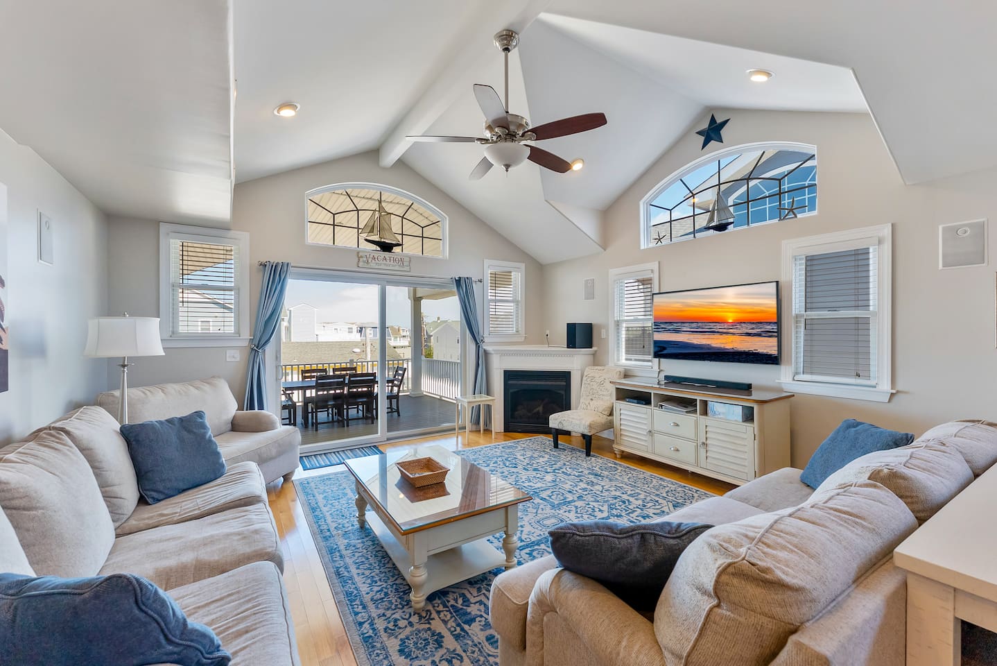 Spacious Living Room with fireplace, HDTV, and access to private balcony with views of the ocean.