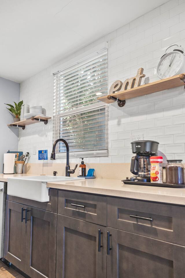 Enjoy the perfect blend of style and practicality in our kitchen, featuring a sleek sink, efficient dishwasher, and coffee maker. A cheerful plant brings life to the space, making it a great spot for cooking and relaxation.