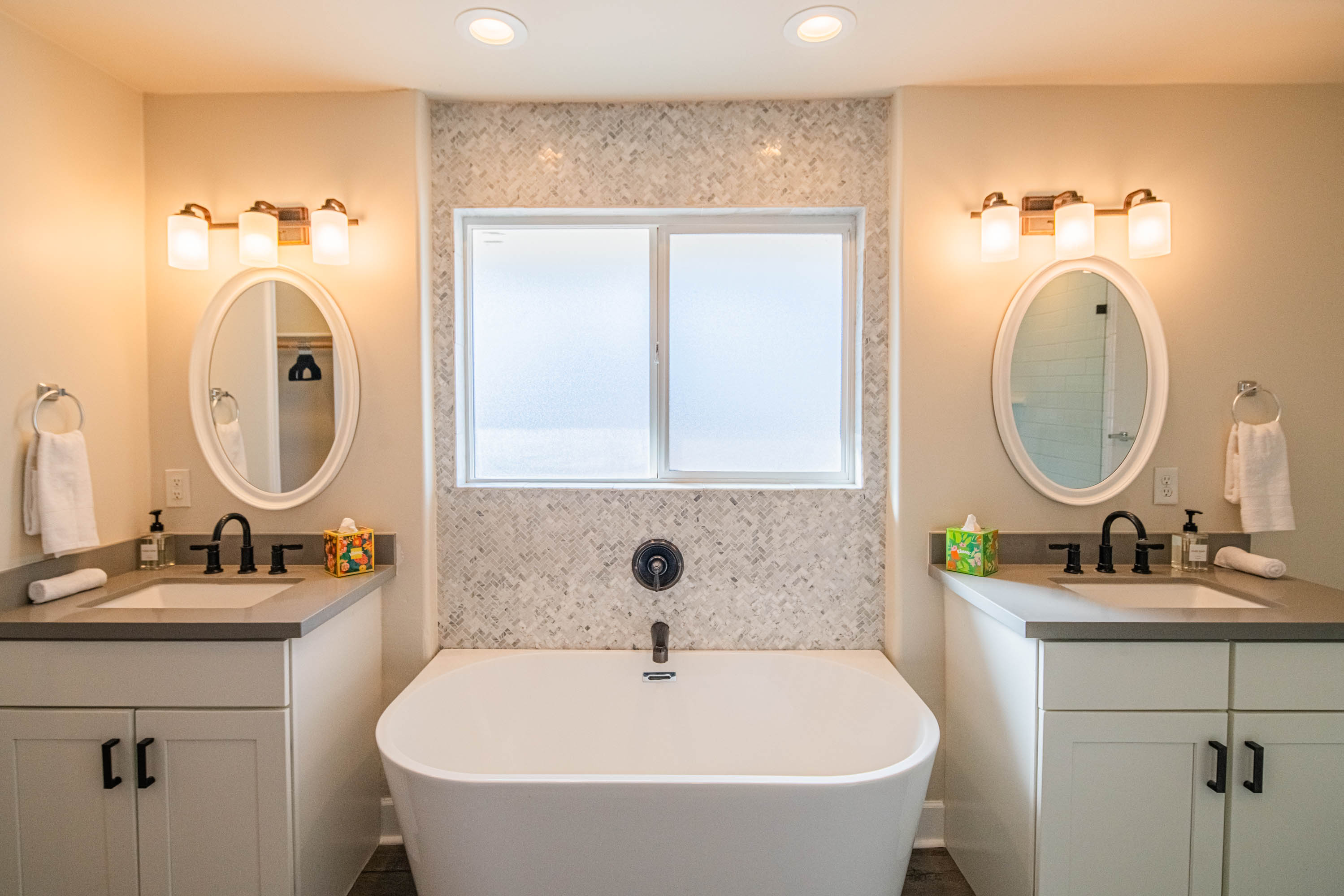Spa-style bathroom featuring a soaking tub, double vanity, and stylish finishes — perfect for unwinding and recharging during your stay.