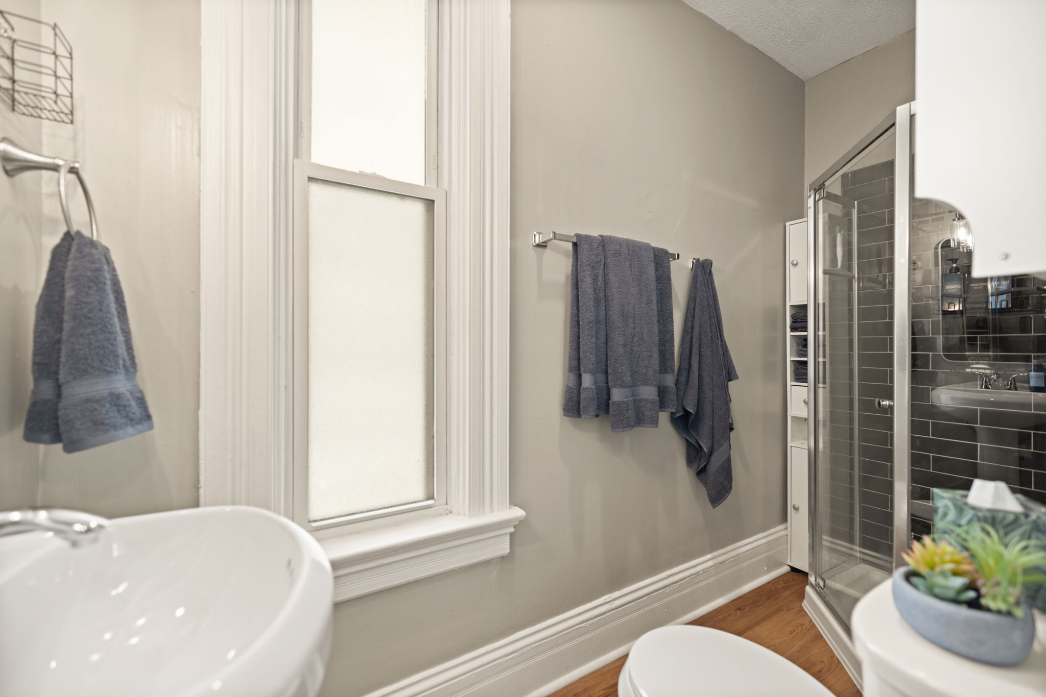 Clean, bright bathroom with tile shower and fresh towels provided