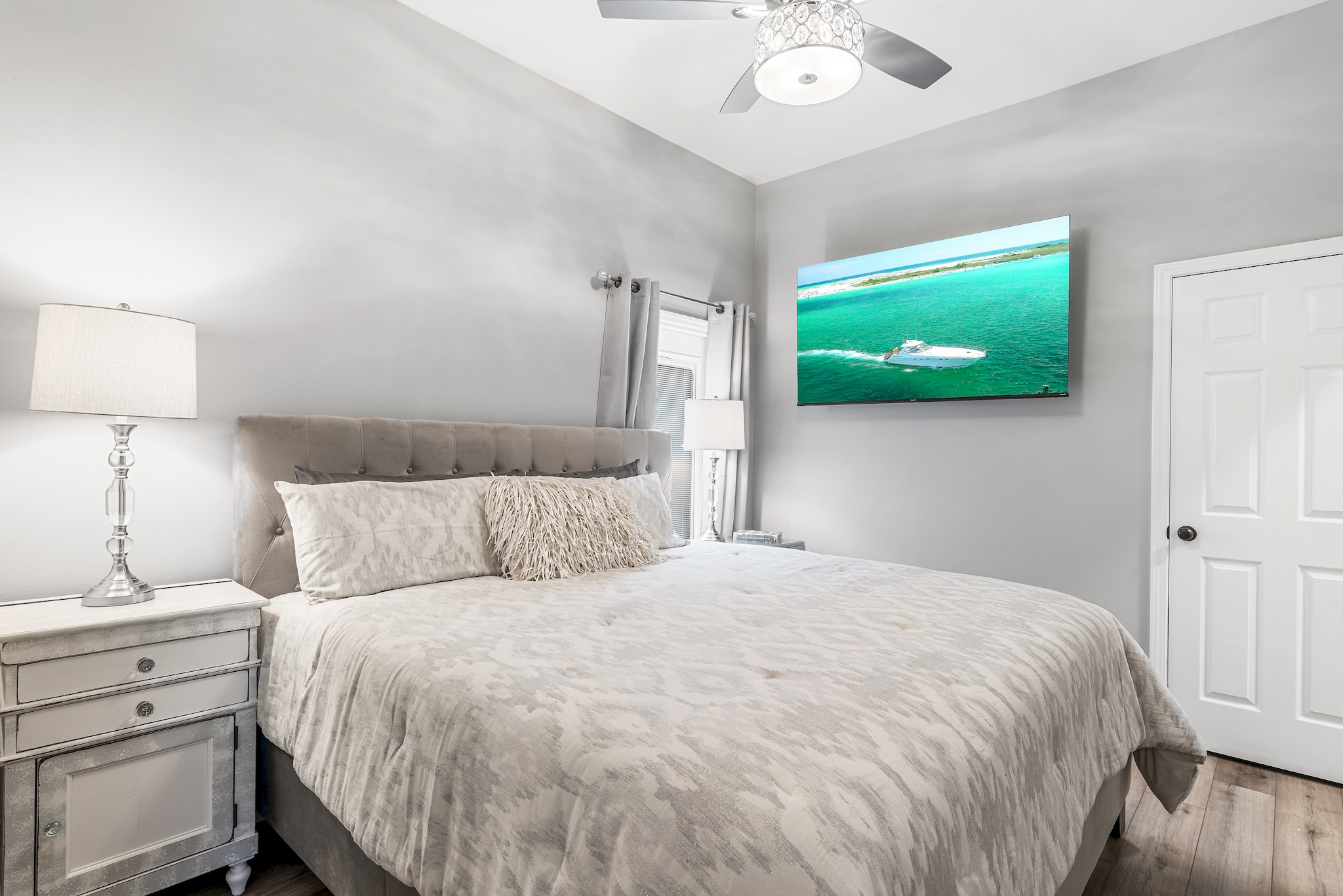 Second master bedroom MIL SUITE with king bed and wall‑mounted Smart TV