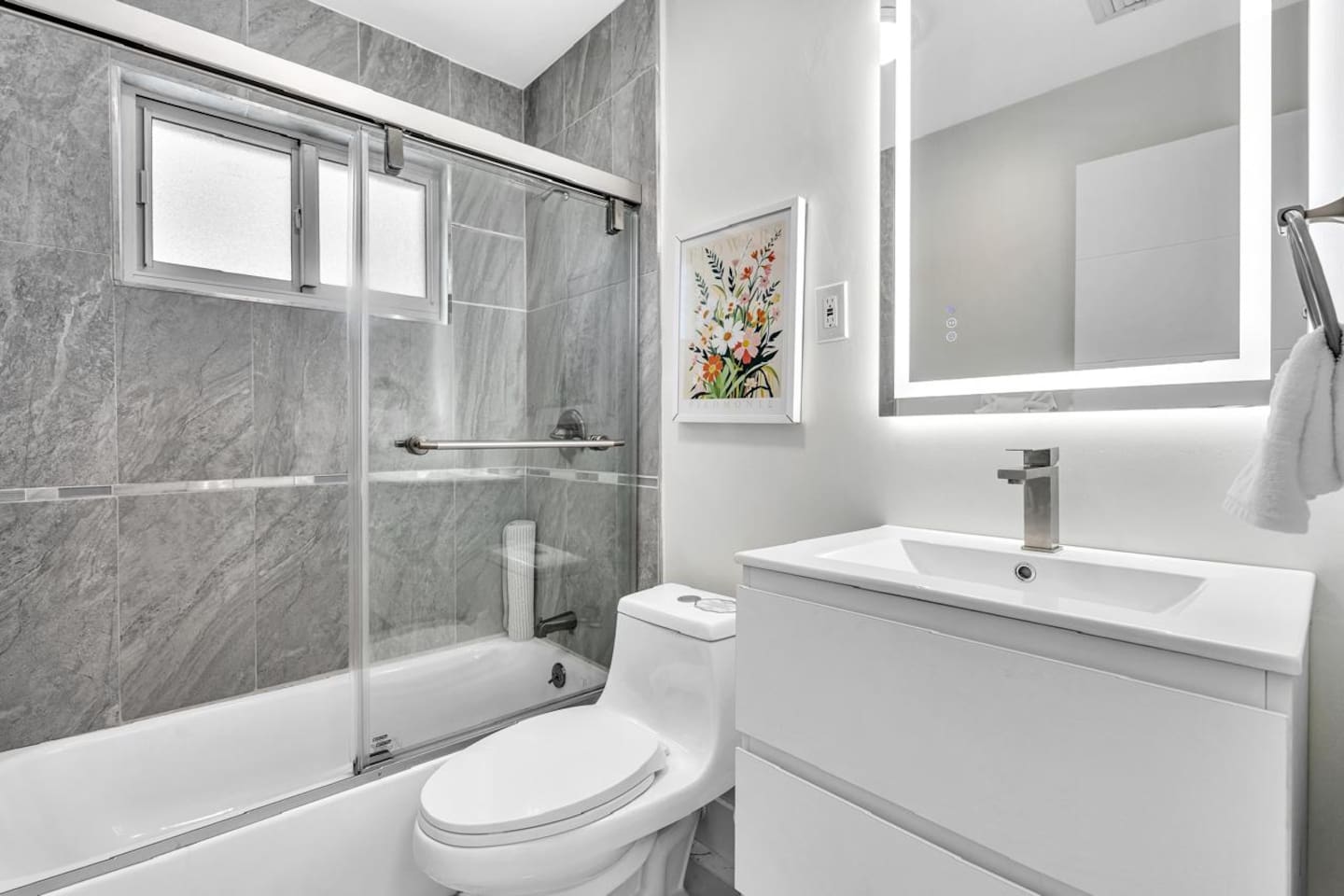 Freshen up in this bright, modern bathroom with a relaxing  tub and shower combination.