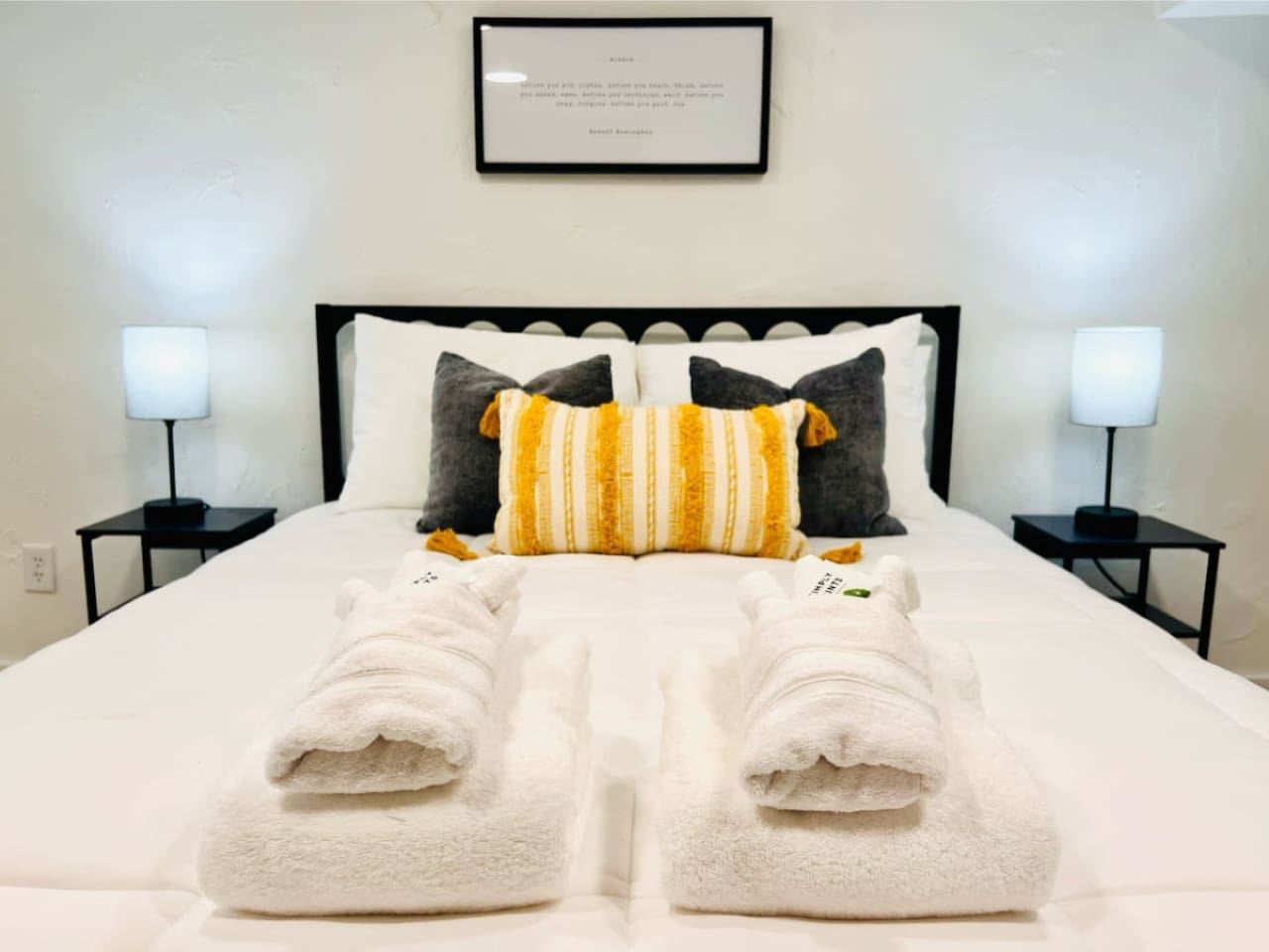 Queen sized bed with fresh sets of towels. 