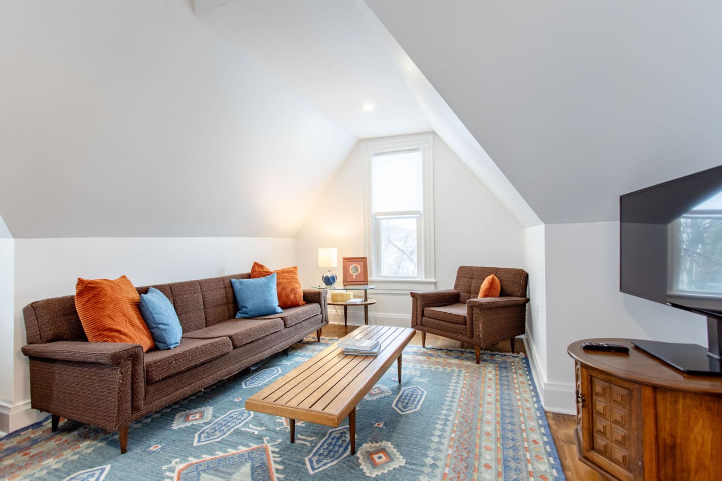A cozy living room with plush couches arranged around a flat-screen TV, perfect for relaxation and entertainment.