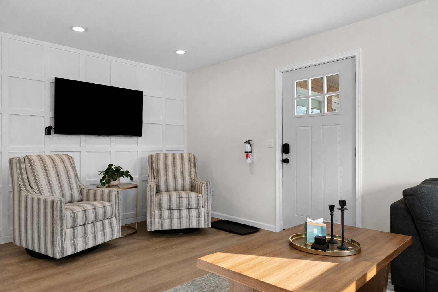 Settle into this bright living area with cozy accent chairs, a smart TV, and modern finishes—welcoming you home with comfort and style from the moment you arrive.