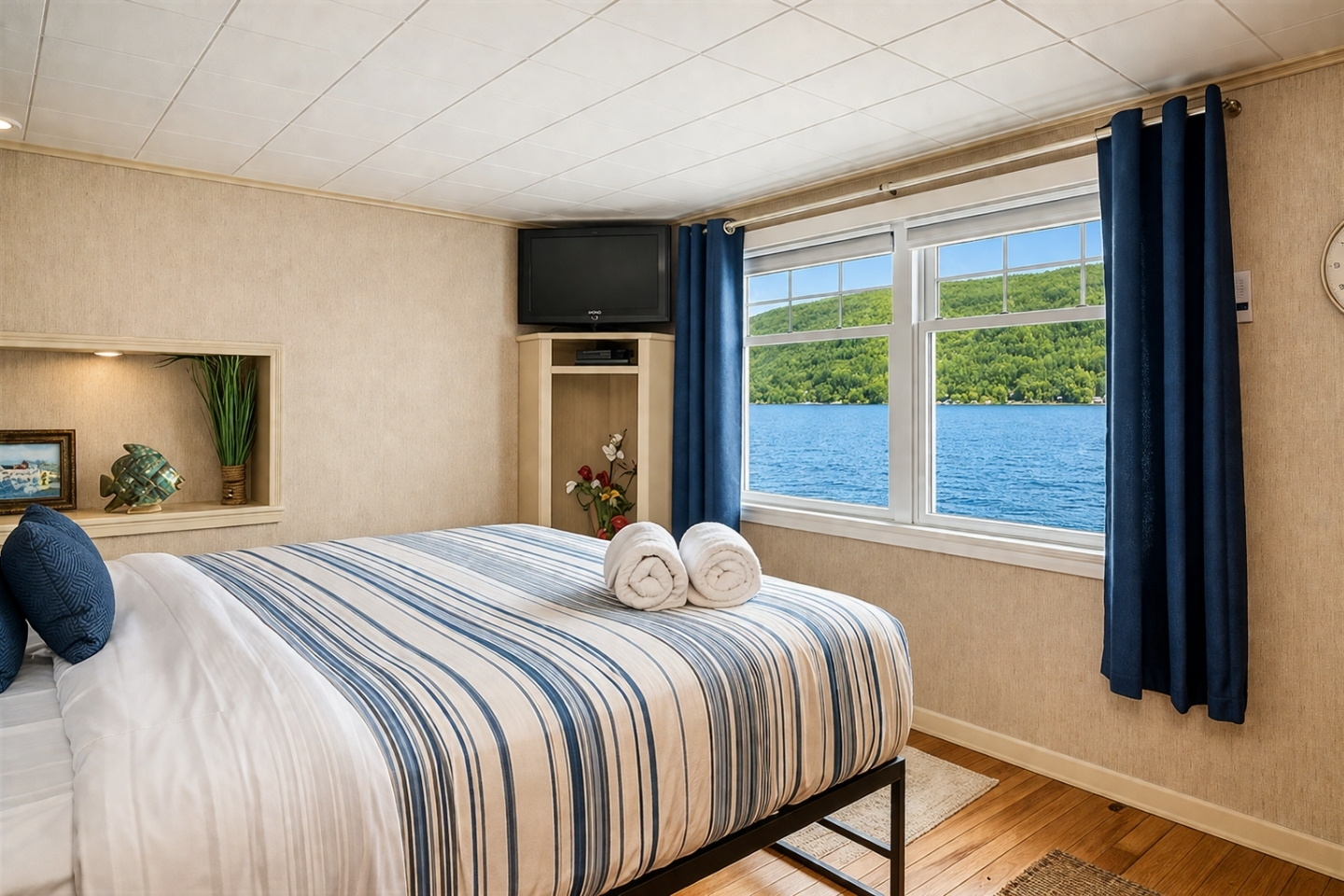 Relax in this tranquil bedroom with oversized windows showcasing breathtaking lakefront scenery, offering the ultimate in waterfront serenity.