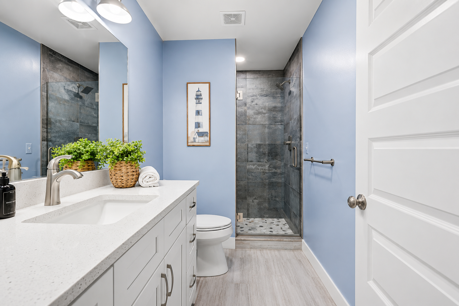 The third-floor full bathroom features a spacious walk-in shower, modern coastal finishes, and a bright, inviting design—perfect for refreshing after a day on the water.