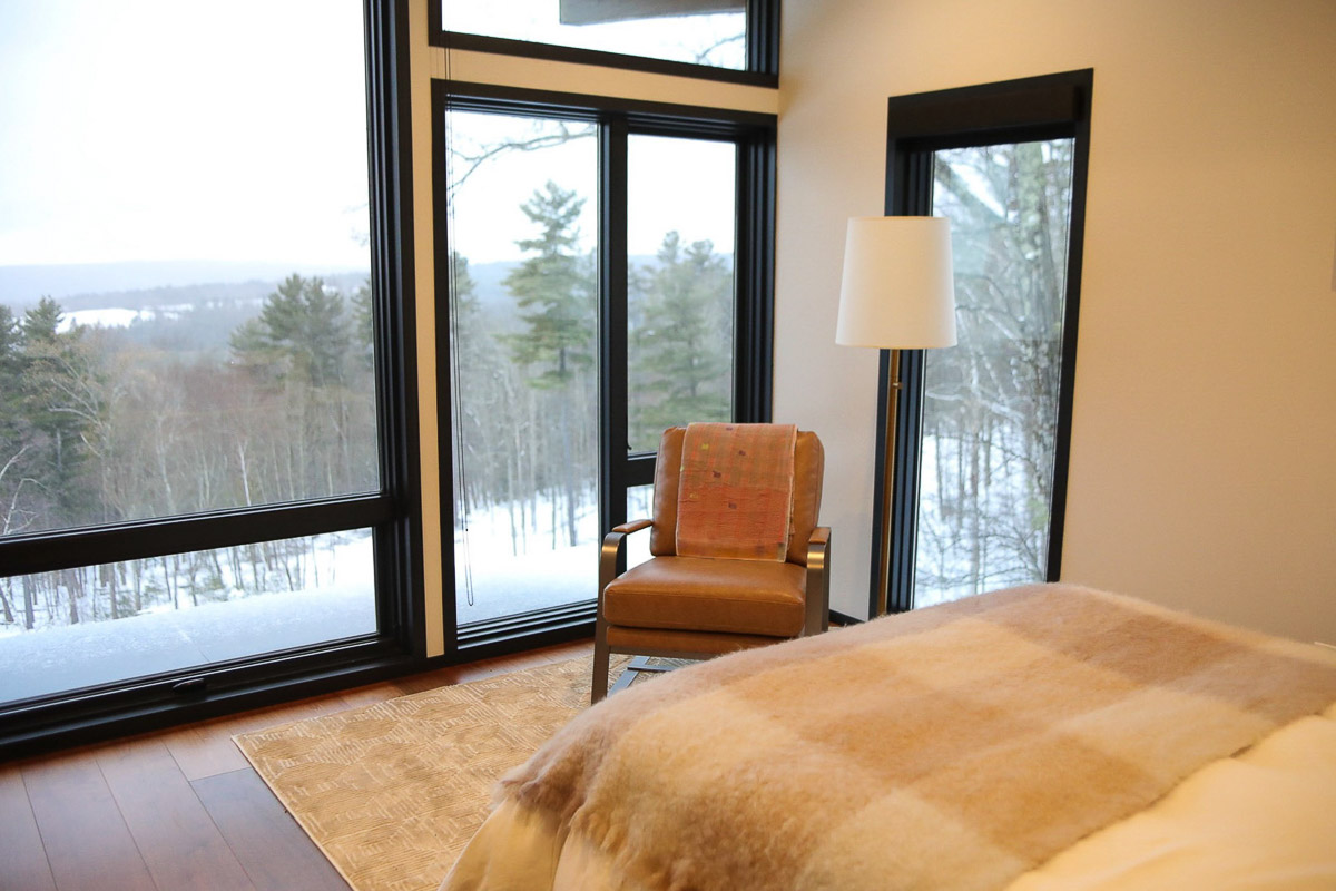 Bedroom Two at Sunset Falls &mdash; floor-to-ceiling windows, winter light through the glass