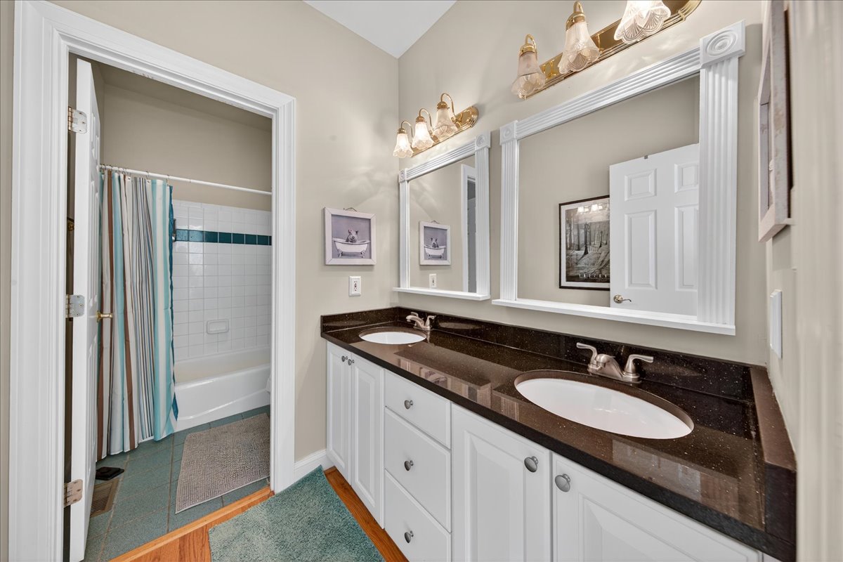 Shared bathroom with dual vanities and tub/shower combo.