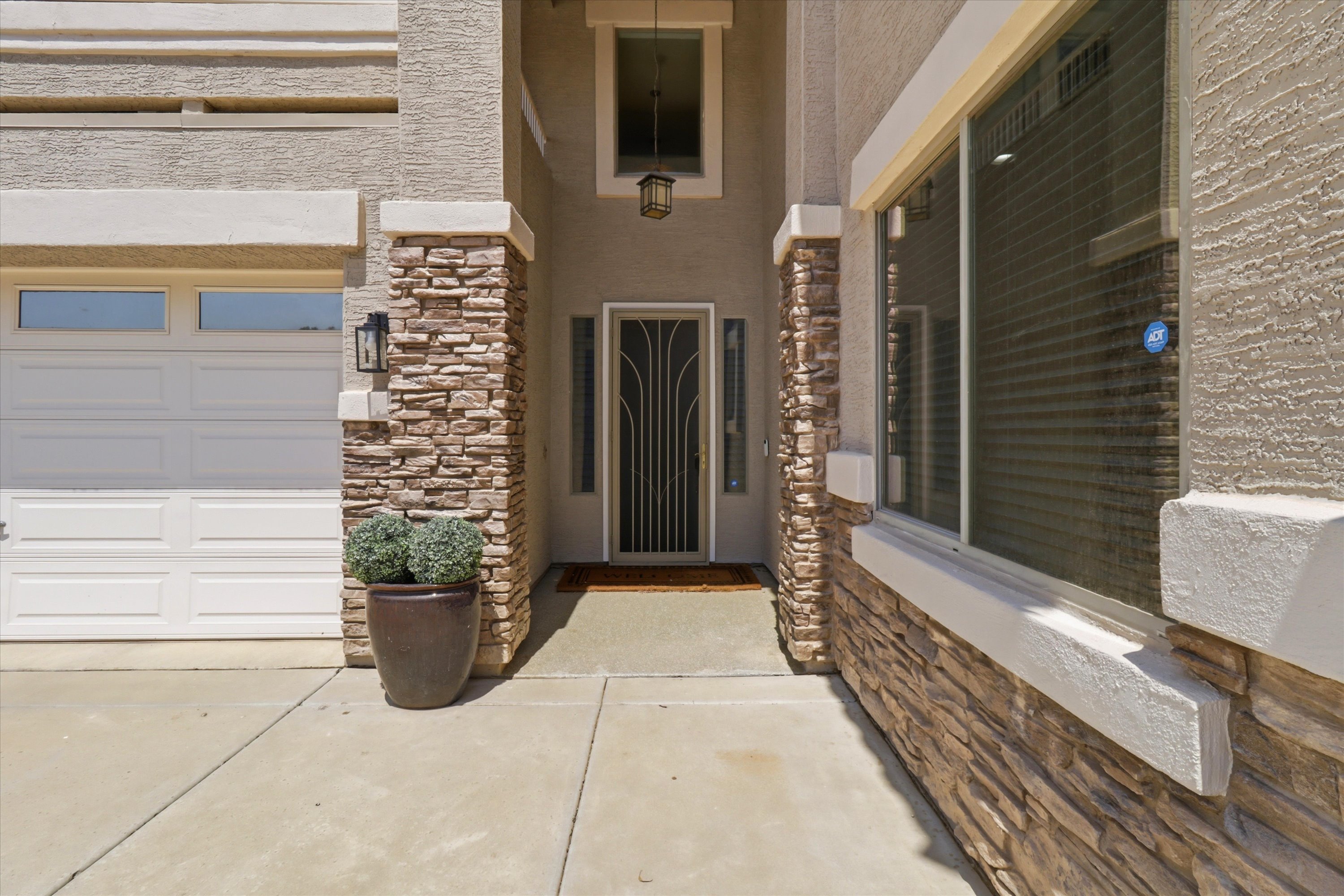 Front entry with stone accents, covered doorway, and direct garage access nearby.
