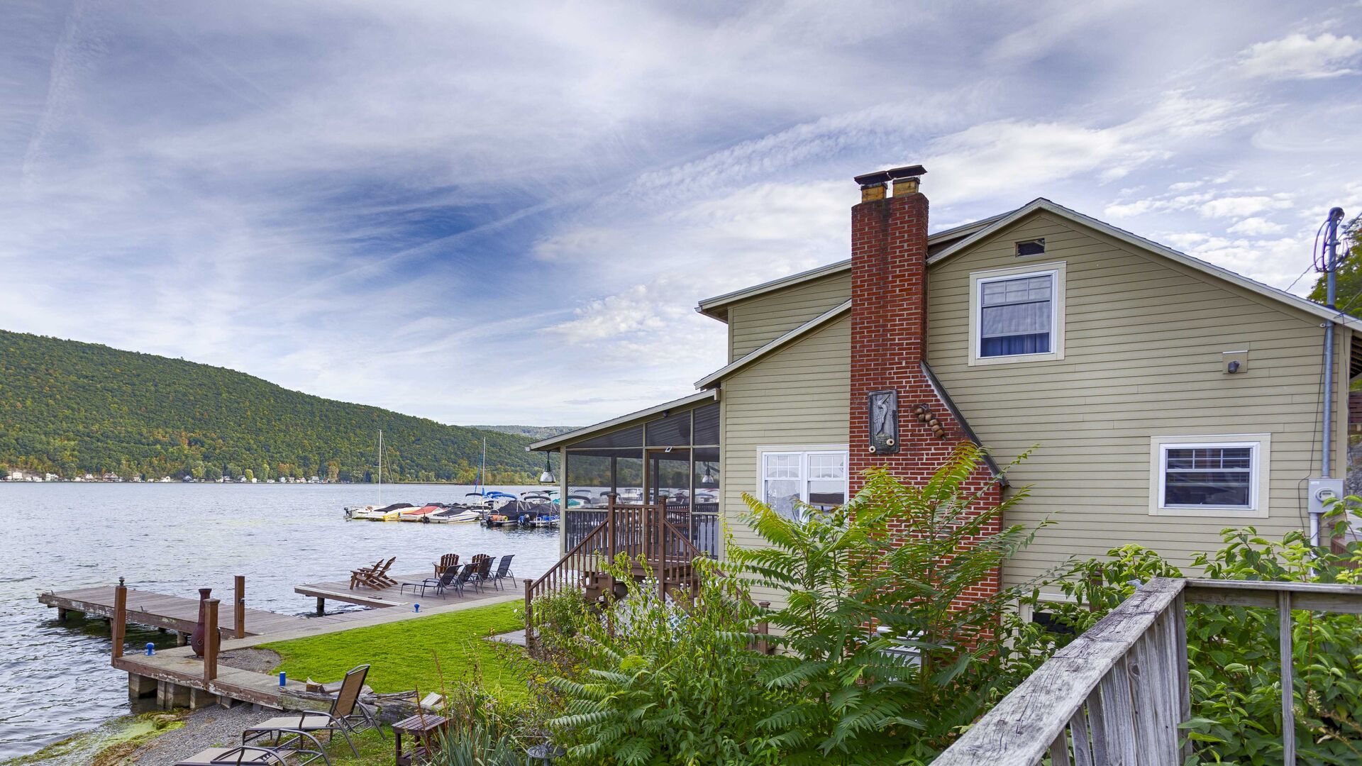 Discover the charm of this remarkable home with a captivating side view that reveals a private dock extending gracefully into the water. From this perspective, the house beautifully blends with its serene lakeside surroundings, offering the perfect s