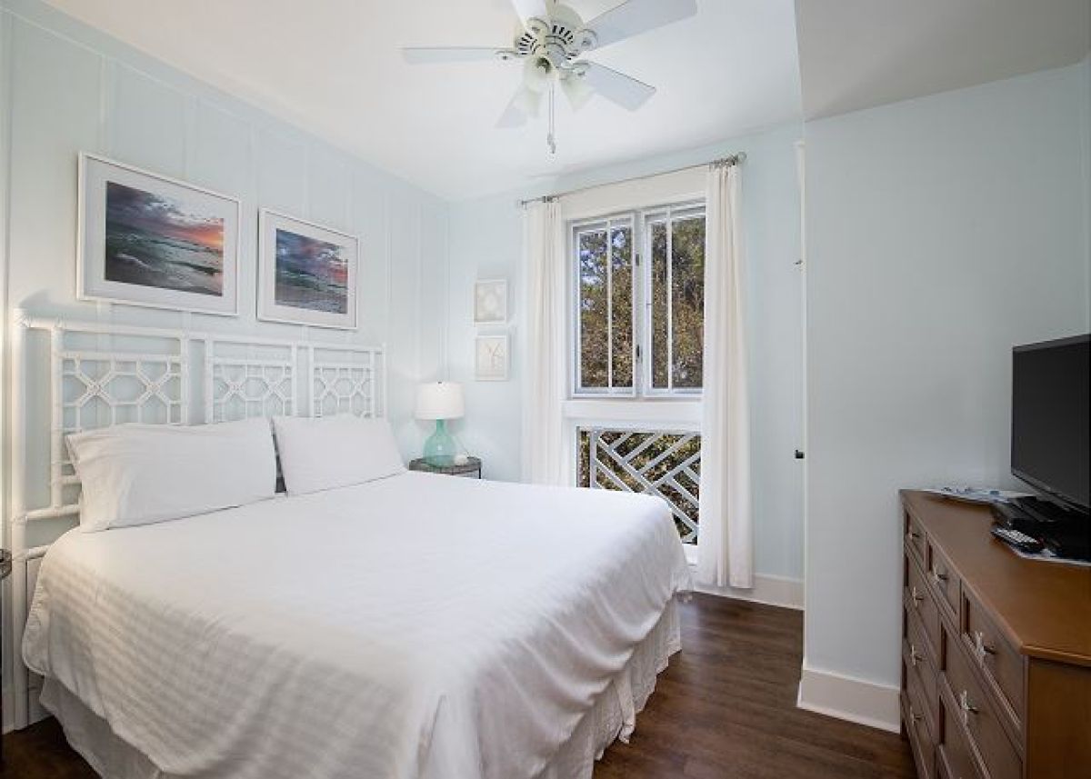King master bedroom with HDTV, dresser, ceiling fan and a window with resort garden views