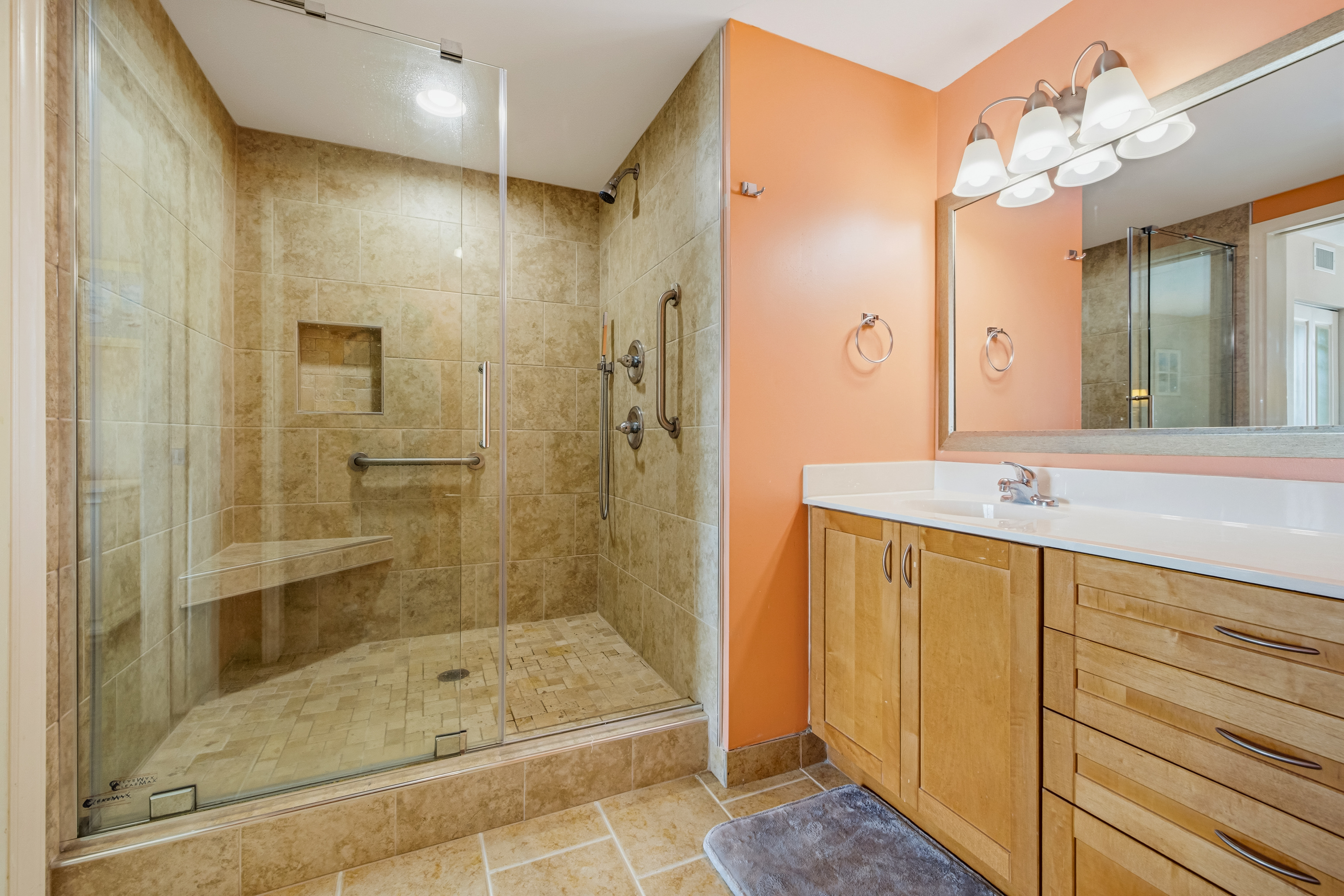 A tiled walk-in shower with a built-in bench. Rinse the salt off in style ⭐