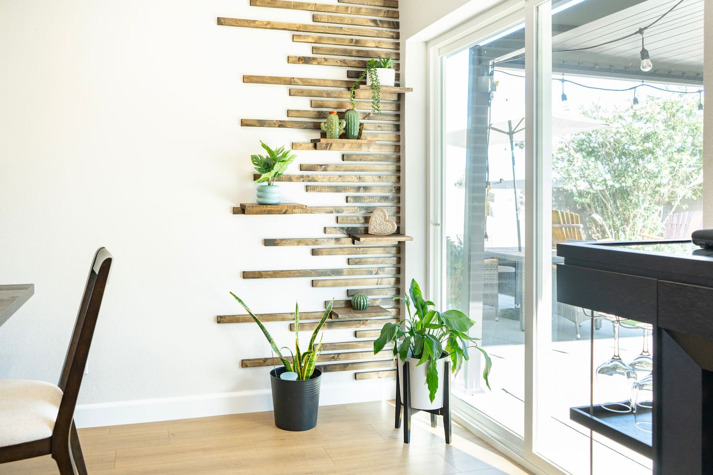 Stylish dining area with custom wood accent wall and indoor greenery, adding a warm, modern touch to your stay