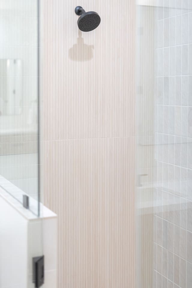 Walk-in shower with rainfall showerhead and clean tile finishes.