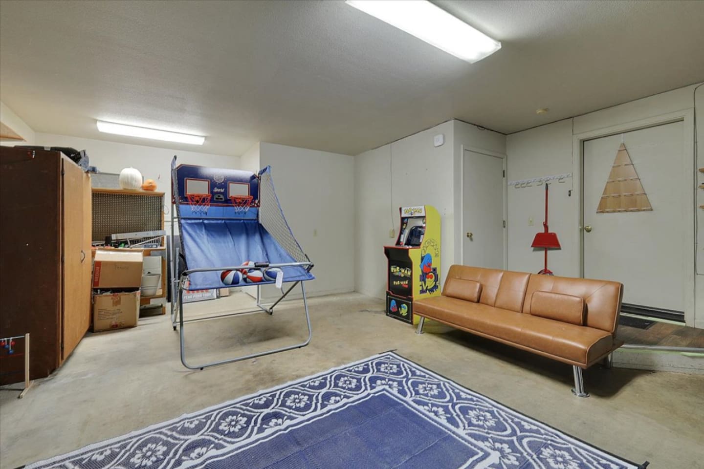 Game room with arcade games, basketball toss, sofa seating, and extra space to hang out.
