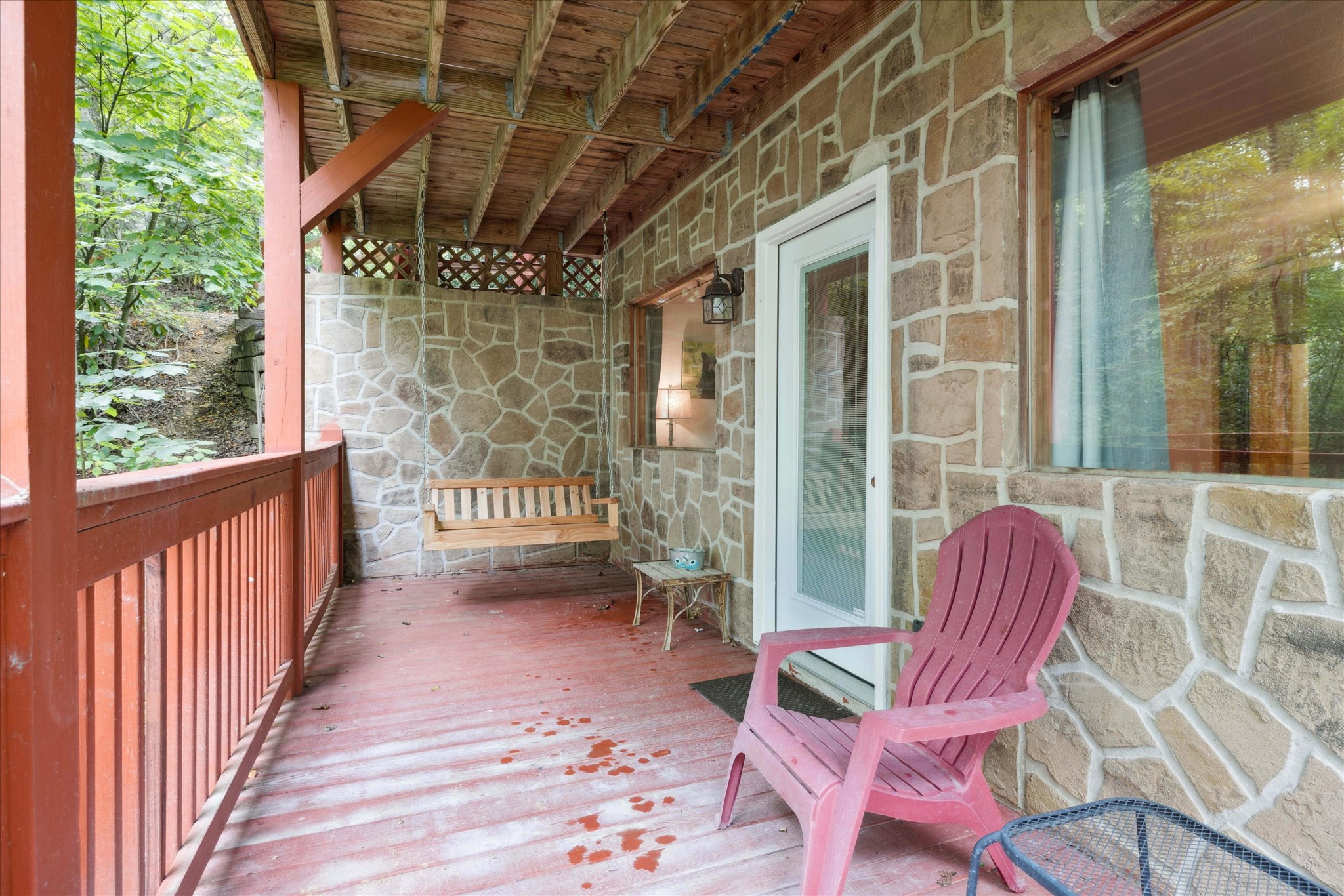 Lower deck outside of bedroom with swing and seating