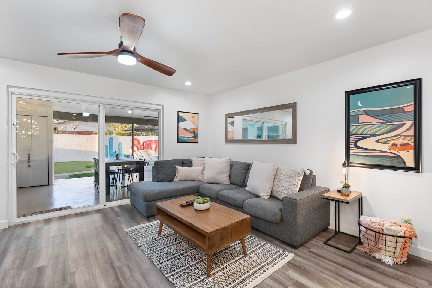 Unwind in this inviting living room featuring a plush sectional, modern artwork, and direct access to the outdoor oasis.