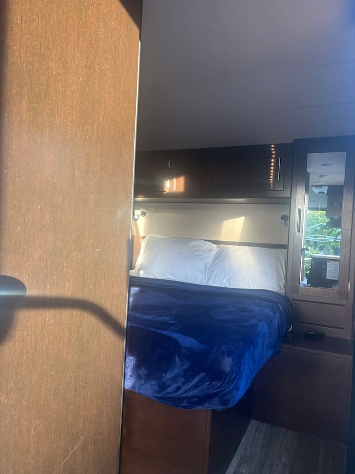 Bedroom - queen size bed with closets on each side. Place to charge phones and set deinks. Lights above bed for reading.