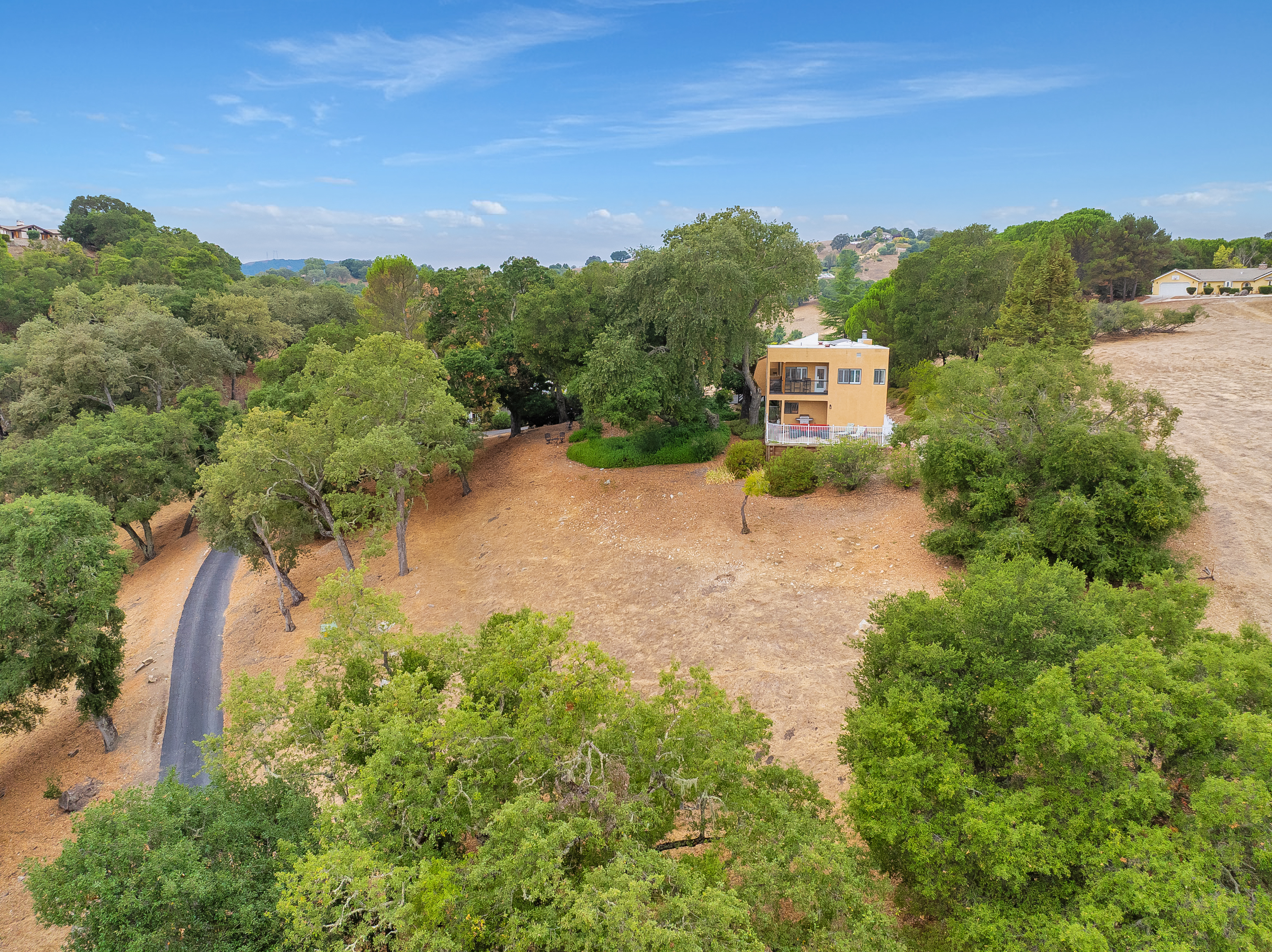 The home is nestled within a vast canopy of mature oak trees, offering absolute tranquillity and panoramic vistas of the distant valley and hills.