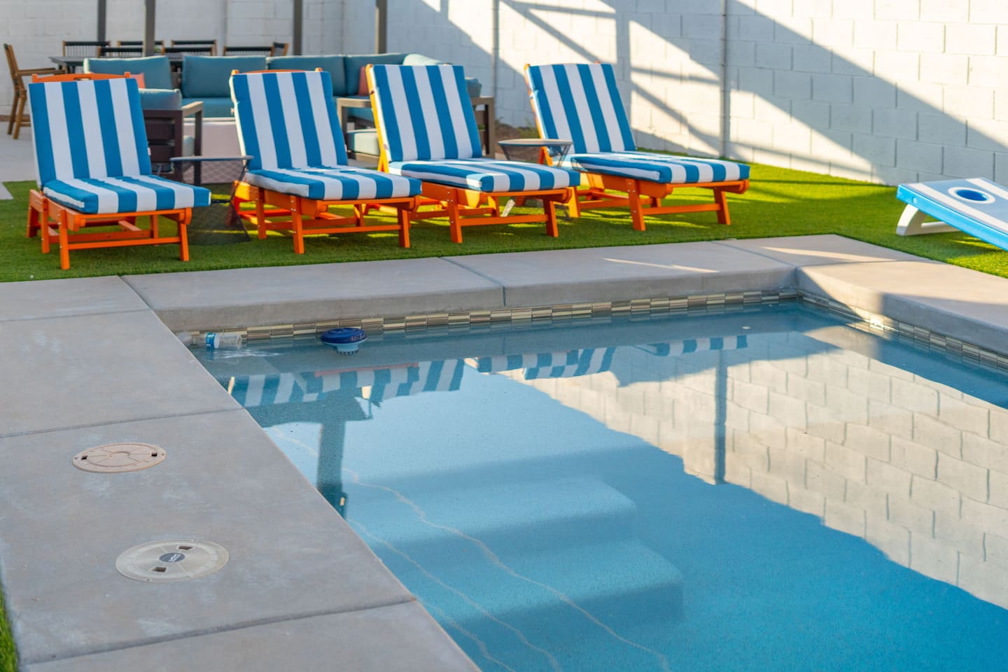 Sparkling pool with colorful striped loungers, perfect for soaking up the Arizona sun.