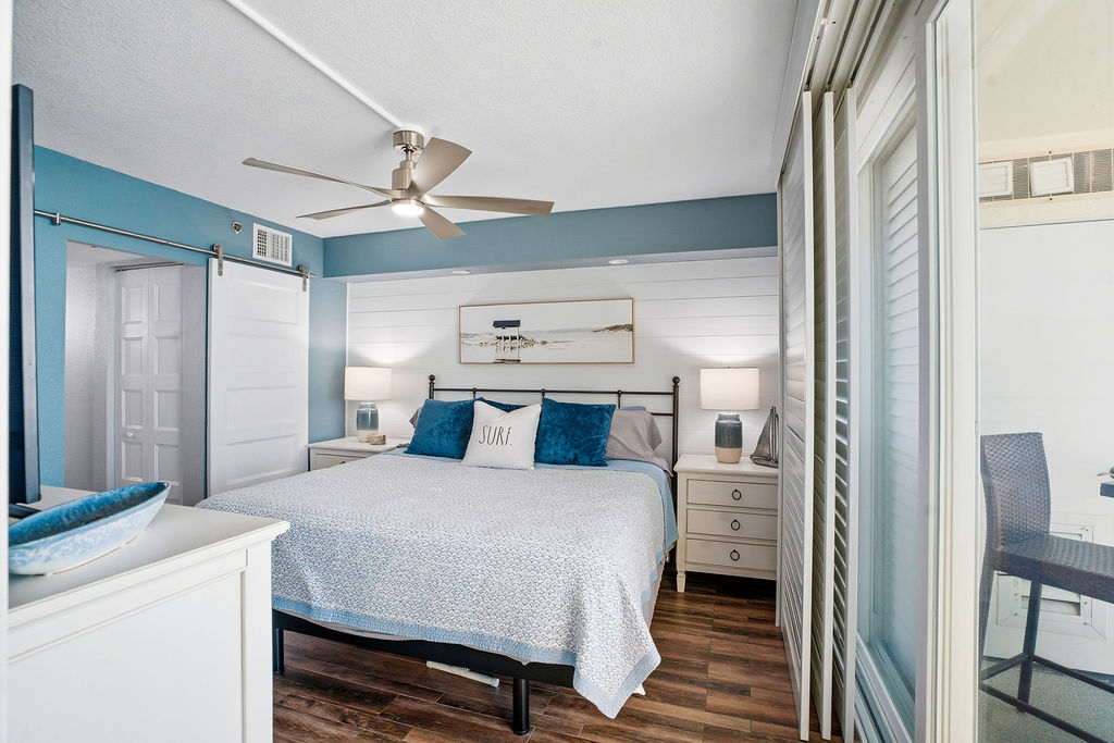 Coastal master bedroom with balcony access and comfortable furnishings for a relaxing oceanfront escape.