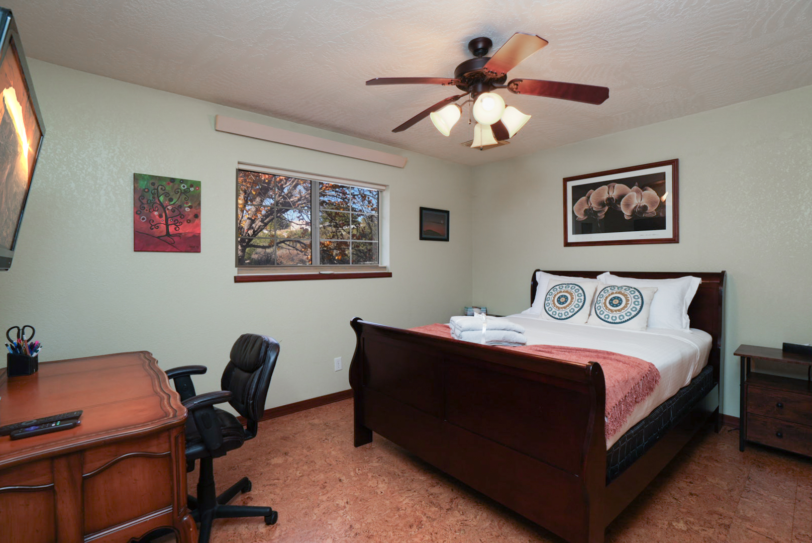 Cozy queen bedroom with smart TV, workspace, and closet—perfect for remote work or a peaceful night’s sleep.