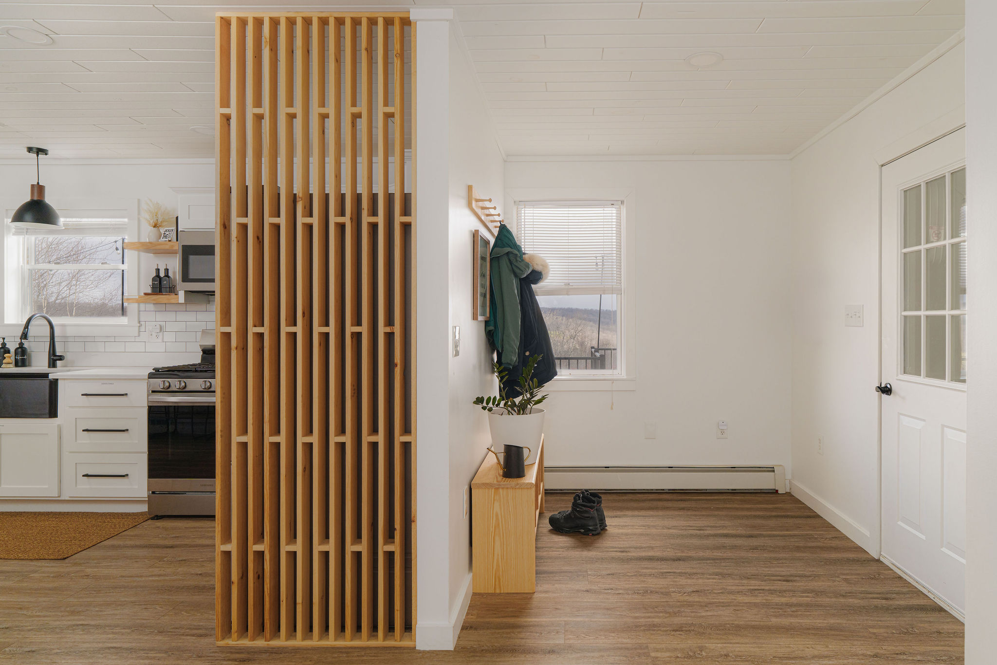 Modern farmhouse entryway with custom wood accent wall and bench.